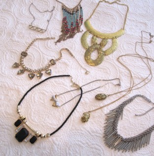 Clockwise from top left: White Feather Designs' geometric silver and gold, Kensington Market graphic beads, E-bay $10 gold collar, 2 long pendants from YYZ Imports, H&M silver fringe, black and gold statement piece from a garage sale, Joe Fresh $5 sale baubles/rinestone necklace